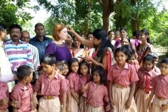 the lead teacher Mukti placing a bindi on Erica
